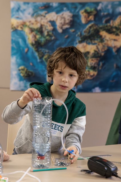 Un petit garçon fait une expérience à l'atelier des petits recollets