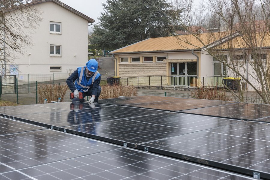Technicien qui met en place un panneau photovoltaique sur la commune de Saulny